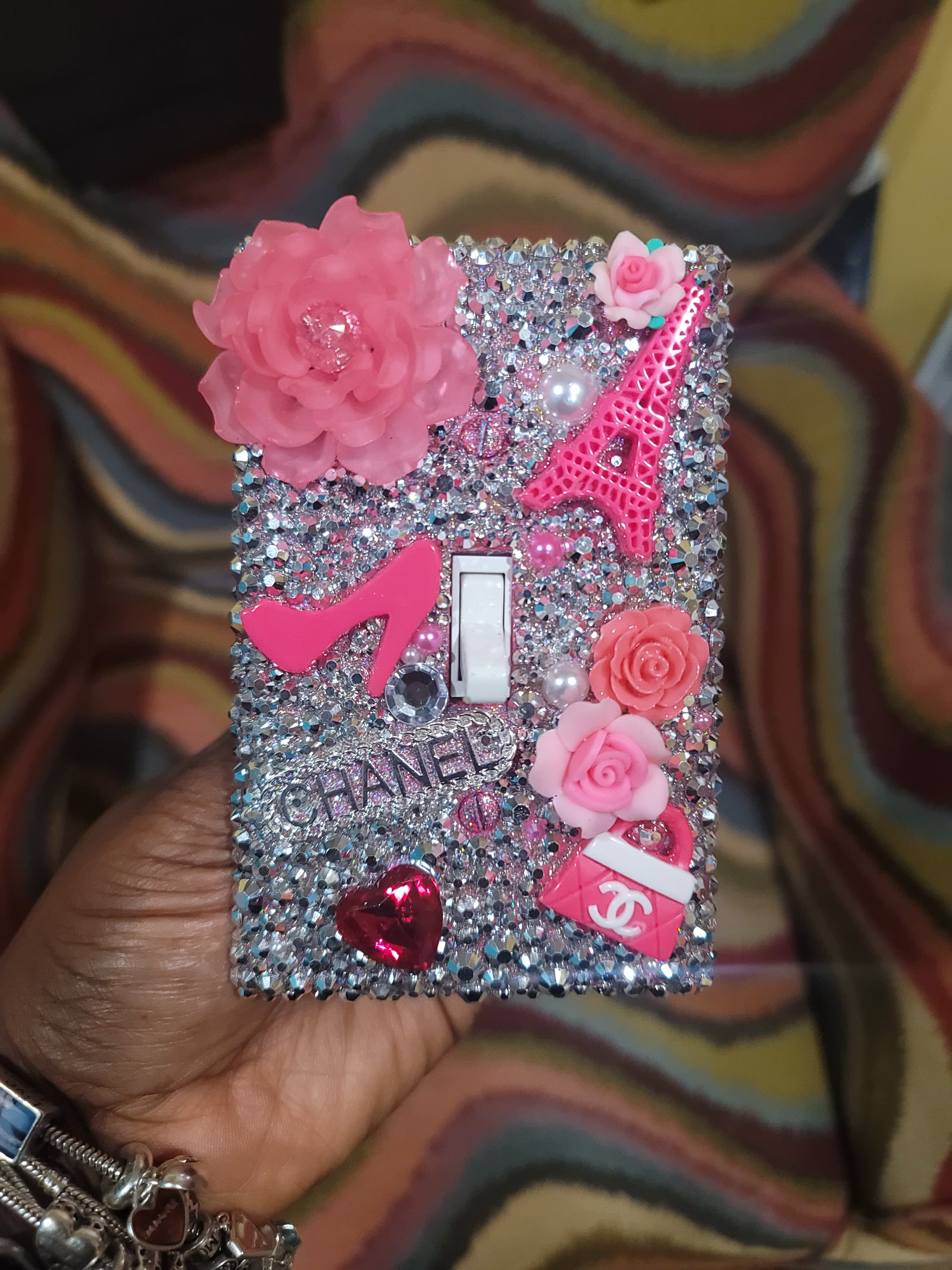Parisian glam rhinestone switch plate covered in silver crystals with pink roses, Eiffel Tower, high heel, Chanel logo and fashion elements, handmade by Black-owned Kustom Kreationz by Kila