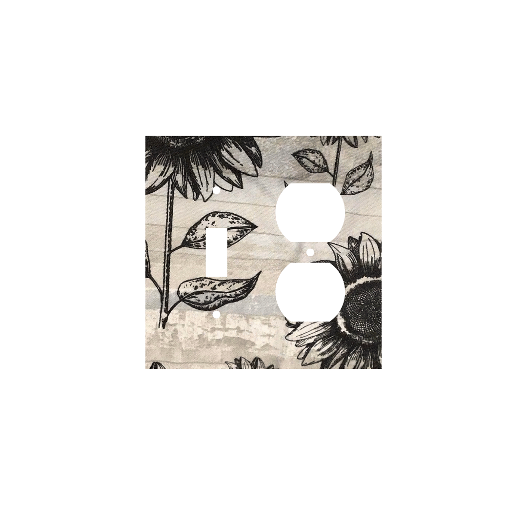 Handmade decorative light switch cover with bold black sunflowers on rustic beige woodgrain fabric, perfect for farmhouse and boho home décor