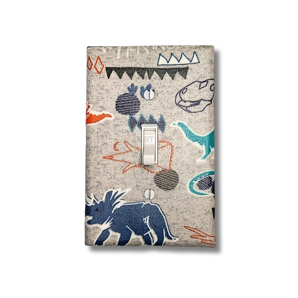 Handmade Roaring Wild Dinosaur Explorer decorative light switch cover featuring hand-drawn T-rex, triceratops, and tribal patterns on natural linen background—kids room switch plates from Black-owned home décor.