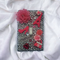 Parisian glam rhinestone switch plate covered in silver crystals with pink roses, Eiffel Tower, high heel, Chanel logo and fashion elements, handmade by Black-owned Kustom Kreationz by Kila