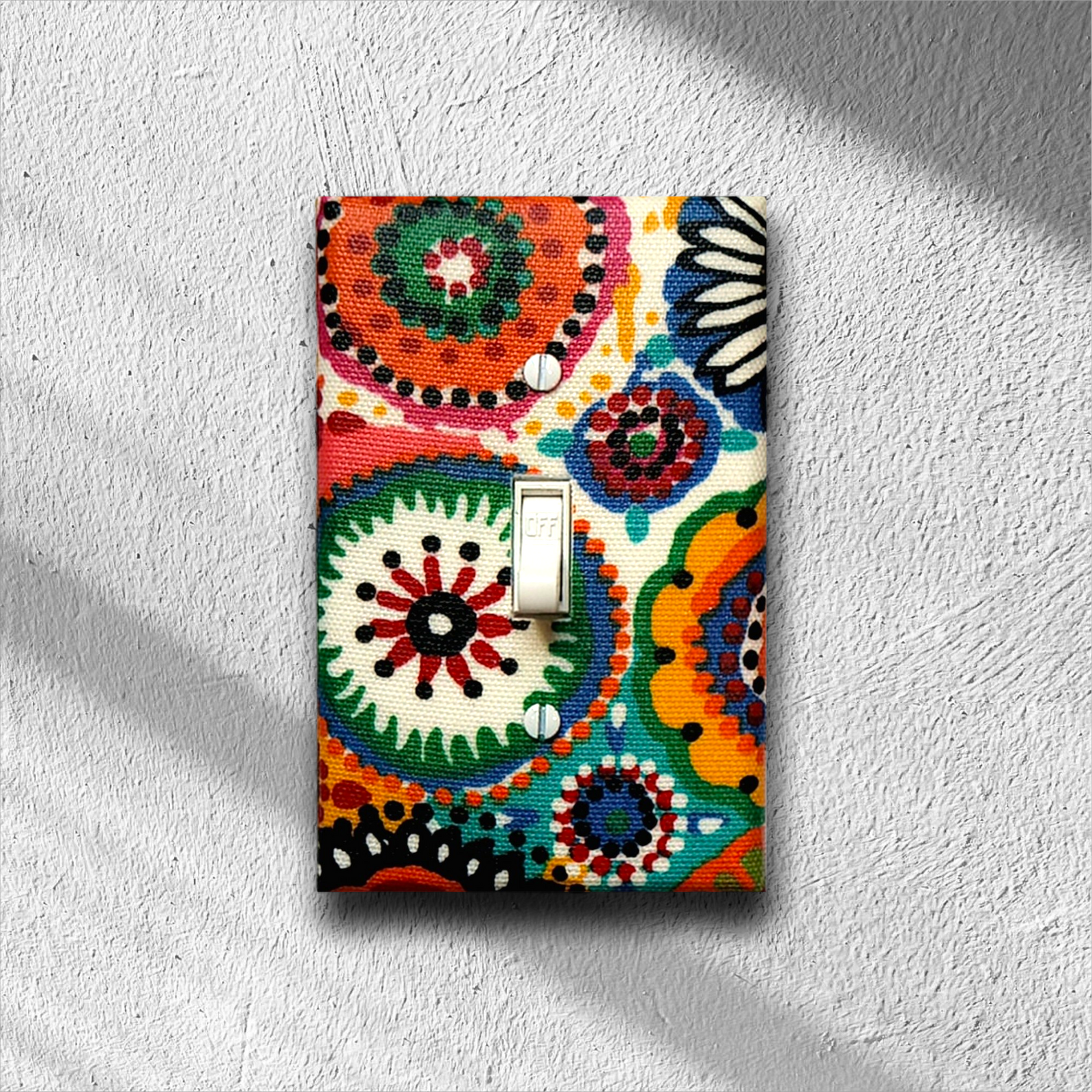 Handmade Rainbow Sunburst decorative light switch cover featuring vibrant African-inspired geometric sunburst and paisley patterns in orange, green, blue, red, pink, and yellow—cultural switch plates from Black-owned home décor.