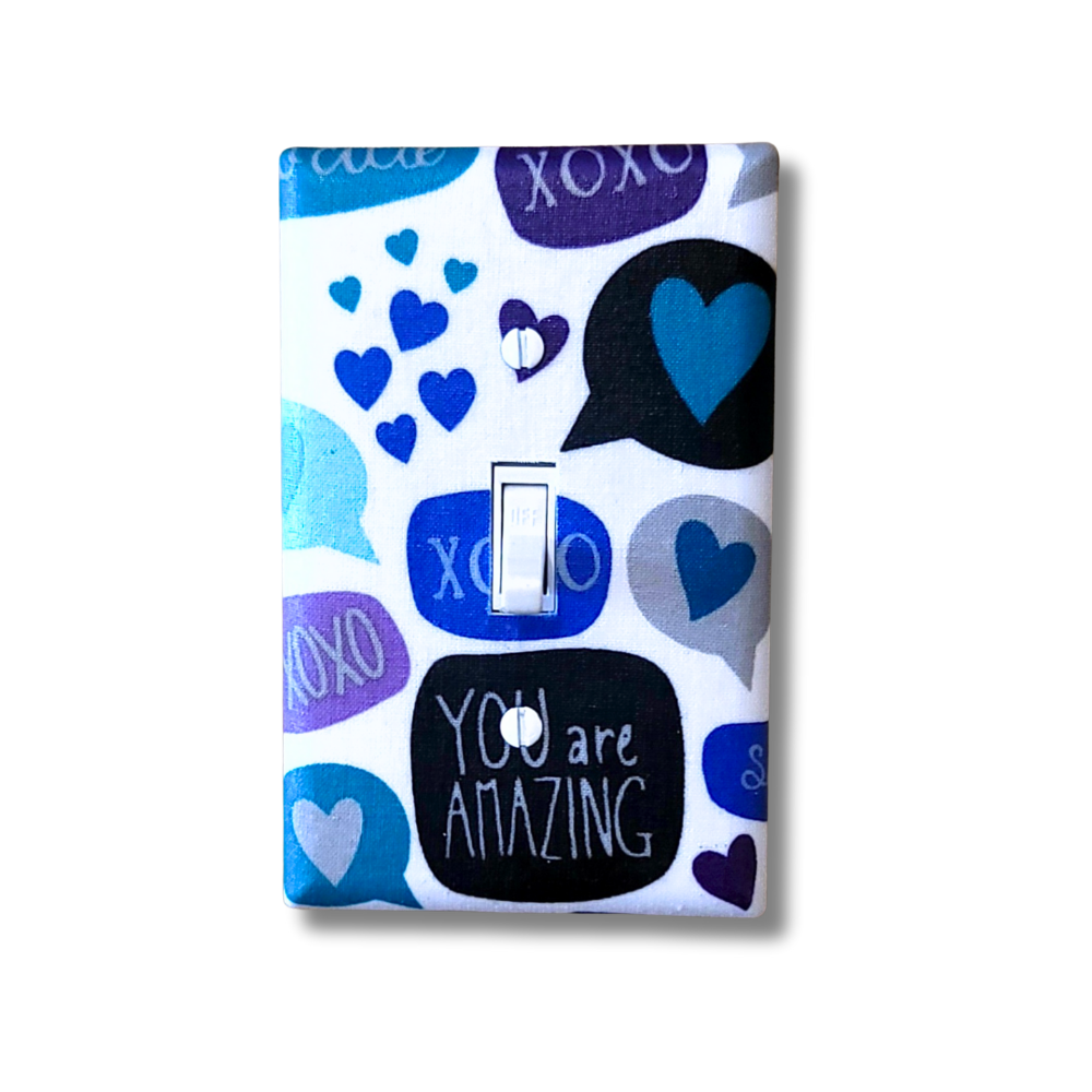 Decorative light switch cover with blue and purple hearts, speech bubbles, and 'You are Amazing' text on a white background.