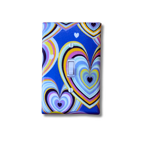 Bright multicolored heart pattern decorative light switch cover on royal blue background, handmade Black-owned home décor
