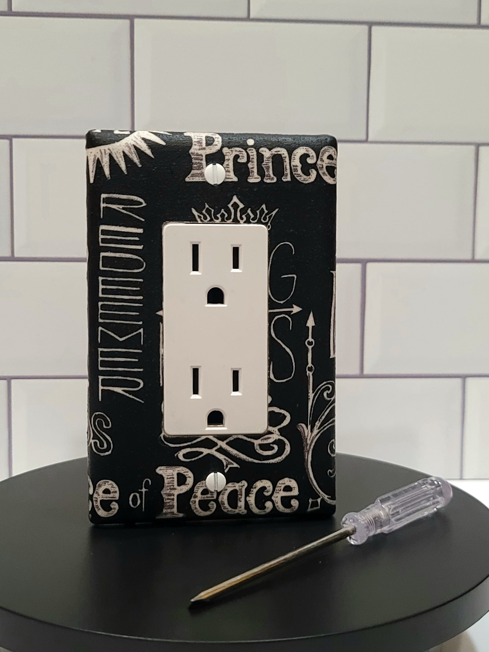Handmade Sacred Declaration decorative light switch cover featuring Christian typography with Prince of Peace, Jesus, Lamb of God on black background—faith-based switch plates from Black-owned home décor.