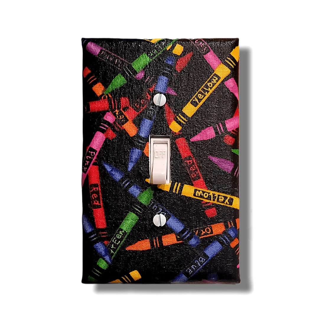 Handmade Color Outside the Lines Crayon Craft decorative light switch cover featuring scattered colorful crayons on black background—art room switch plates from Black-owned home décor.