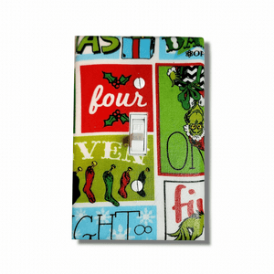 Handmade The Grinch Holiday Spirit decorative light switch cover featuring the Grinch with retro comic panel style and holiday text—officially licensed Dr. Seuss switch plates from Black-owned home décor.