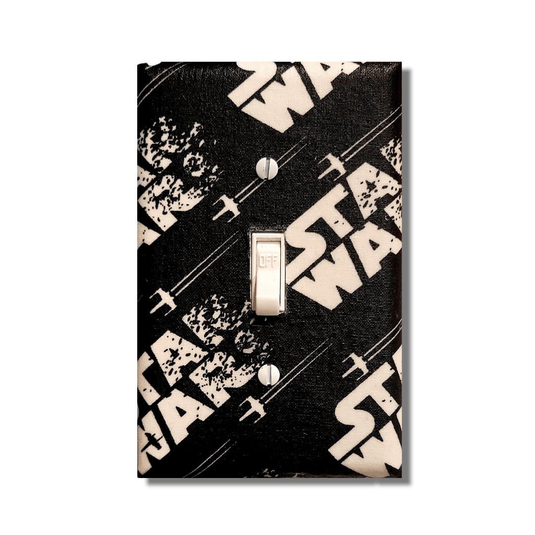 Handmade Star Wars decorative light switch cover featuring vintage black and cream X-Wing design with distressed logo—officially licensed Black-owned fan home décor.