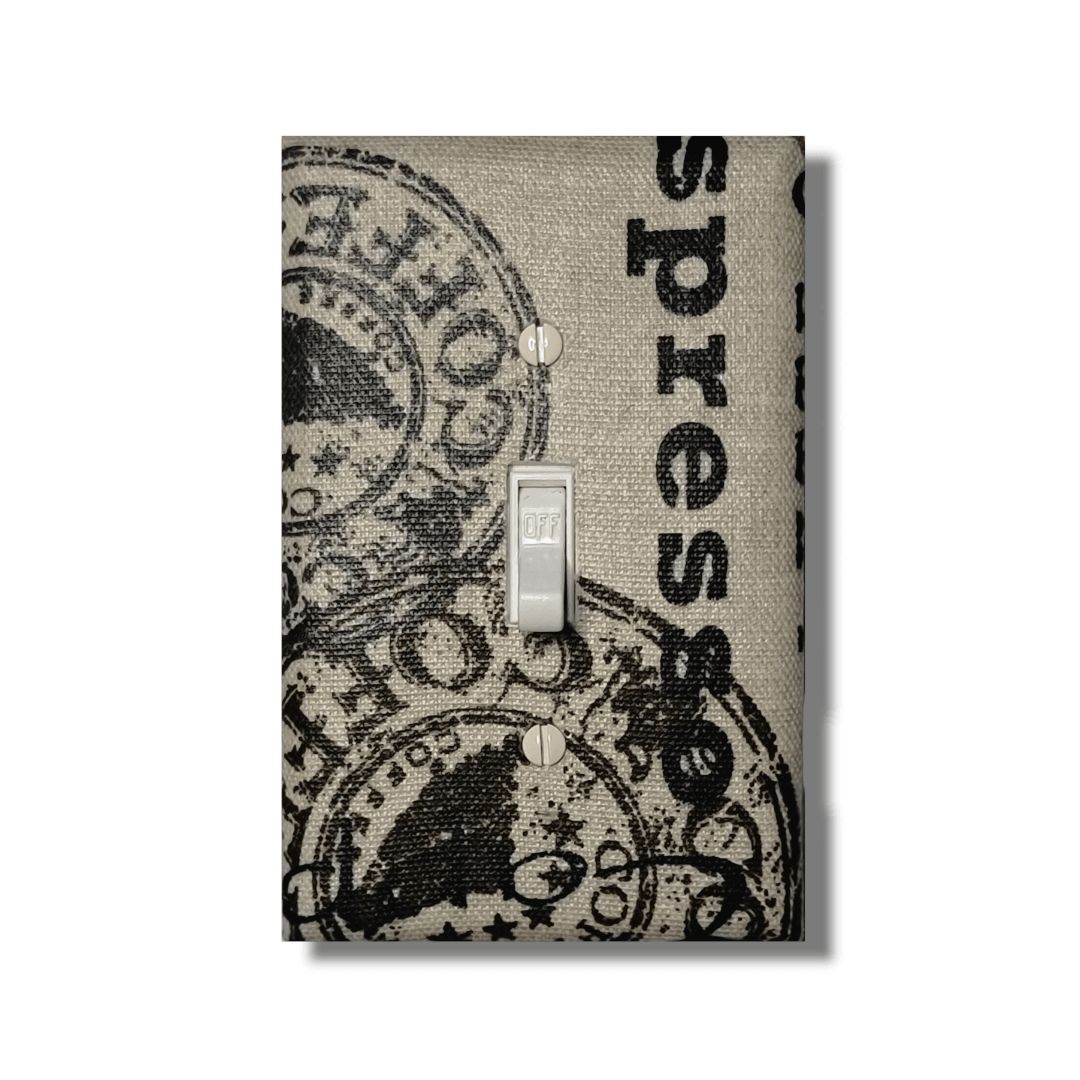 Handmade light switch cover with vintage café postcard design featuring coffee stamps, French typography, and coffee bean motifs in cream and brown for farmhouse kitchen charm