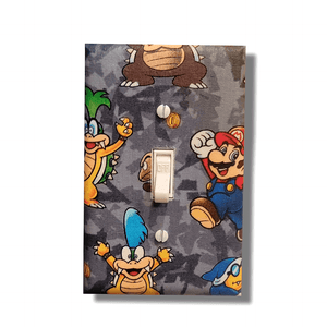 Handmade Super Mario Level Up decorative light switch cover featuring Mario, Bowser, Larry Koopa, and coins on gray camo background—officially licensed Nintendo switch plates from Black-owned home décor.